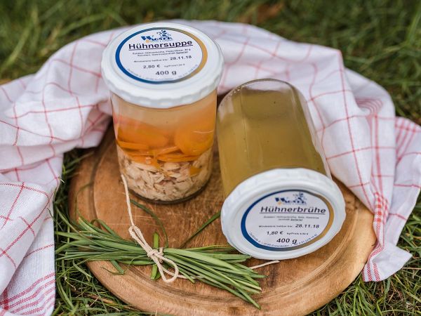 Zwei Einmachgläser mit Hühnerbrühe und Hühnersuppe