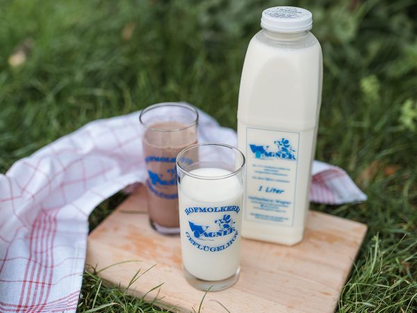 Eine Flasche Kuhmilch und ei Glas mit frischer Kuhmilch und ein Glas mit Kaba